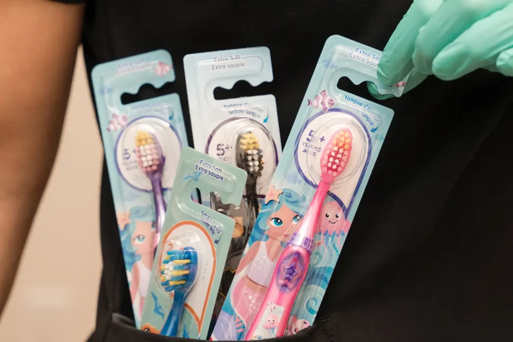 Brosses à dents pour enfants dans la poche d'un membre du personnel au Centre dentaire Boucherville